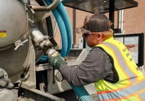 Worker performing septic tank maintenance