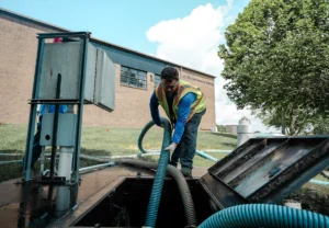 Worker performing septic tank pumping