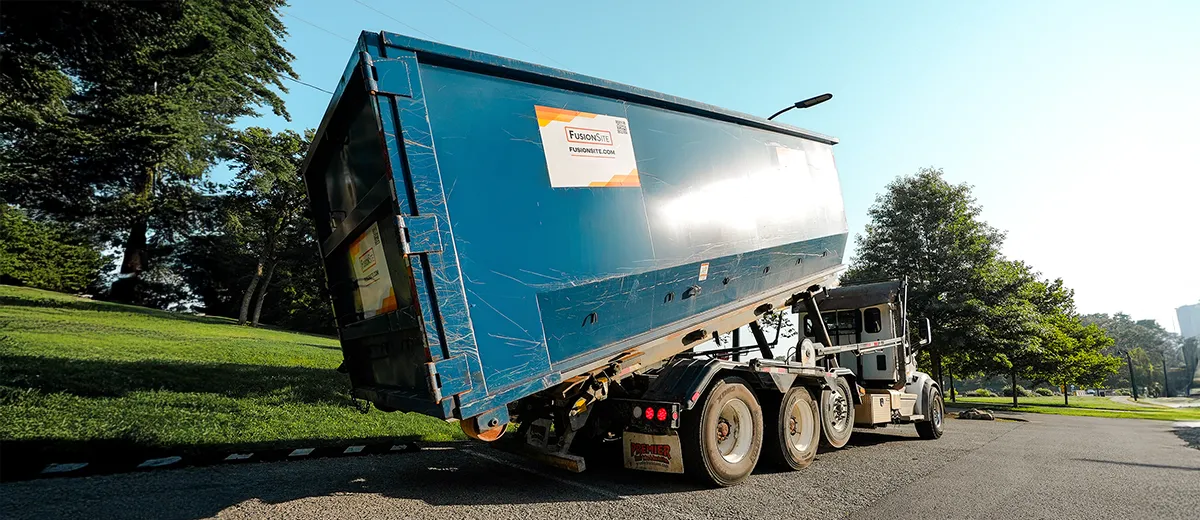 Truck dropping off a rental roll off dumpster