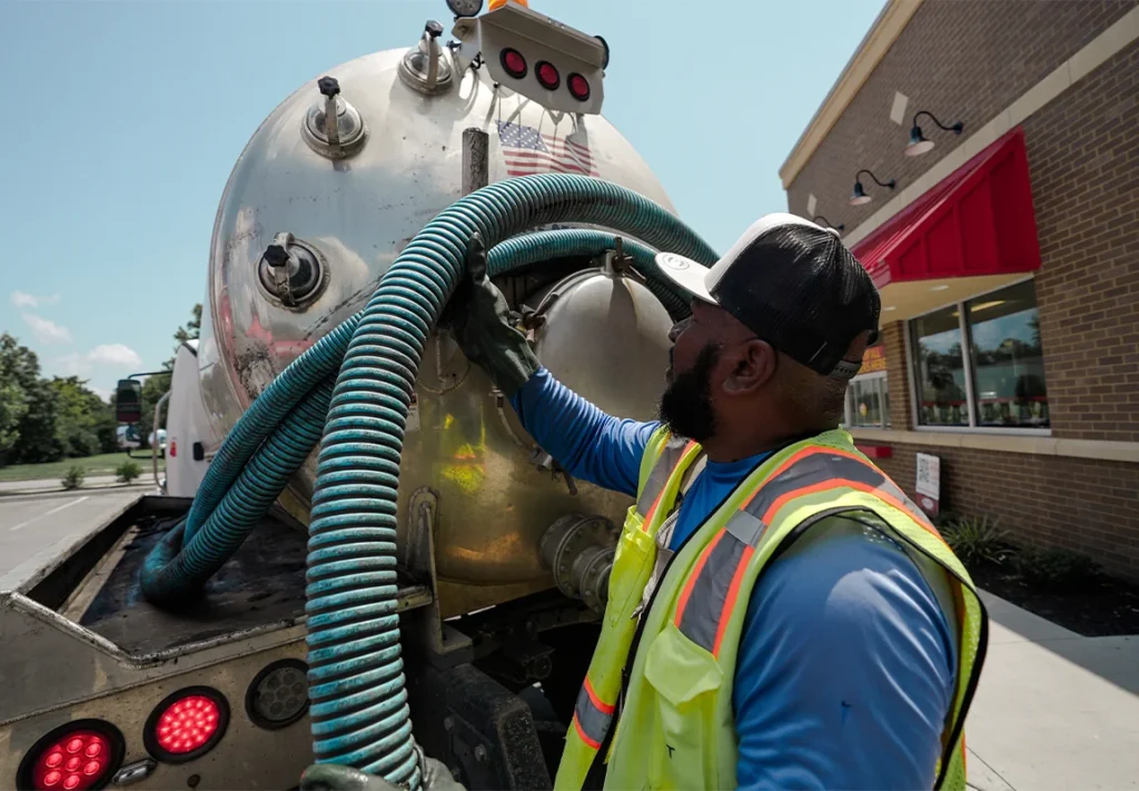 Grease trap service truck with hoses