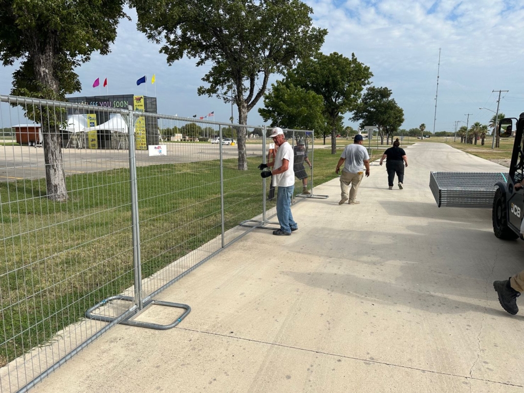 Worker setting up temporary rental fencing