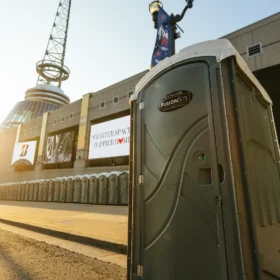 portable toilet at venue focus shot of one toilet with a back row of toilets